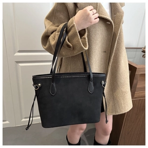 Détail du grand sac cabas noir en daim avec cordons latéraux et finitions dorées chic