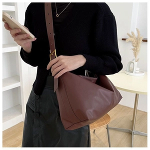 Detail of adjustable strap with gold buckle on a brown leather hobo shoulder bag