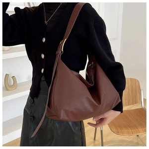 Detail of dark brown leather hobo bag with adjustable strap and gold buckle