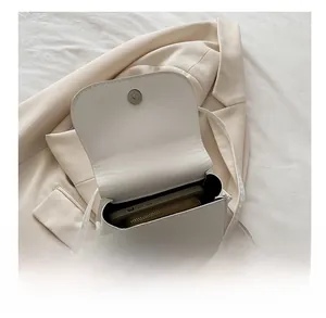 Interior capacity of the white leather saddle bag showing space for phone and wallet