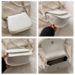 Detail view of white saddle bag showing interior space for phone and adjustable strap