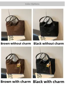 Detail view of large matte leather tote bags in coffee and black with teddy bear charms