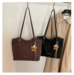Close-up of matte suede tote bags in brown and black with cute bear charms