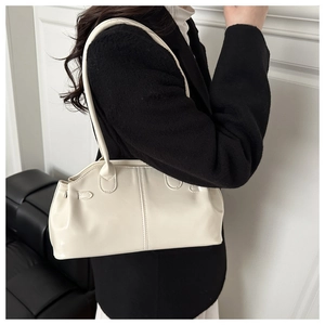 Detail of off-white minimalist shoulder bag with decorative side pleats and smooth leather