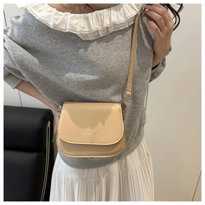 Detail of the chic beige crossbody flap bag with FASHION TREND EST 1993 logo print