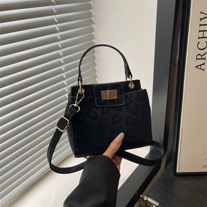 Chic black leopard embossed suede handbag with gold lock and adjustable strap