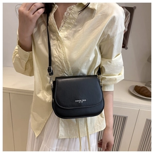 Close-up of black PU leather saddle bag showing adjustable strap and fashion trend logo