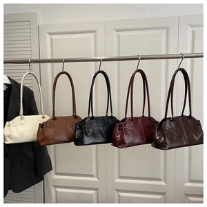 Detail view of large shoulder bags in cream, caramel, black, wine red, and coffee