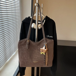Brown frosted leather tote bag with a cute bear charm and golden logo on shoulder strap