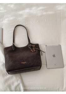 Grand sac cabas vintage en cuir marron mat à côté d'un iPad pour comparer la taille