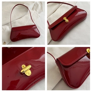 Detail view of red patent leather baguette bag with premium golden metal twist lock