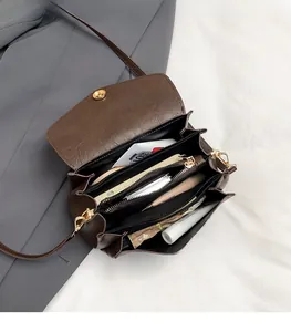 Detail view of the deep brown leather crossbody bag with spacious interior compartments