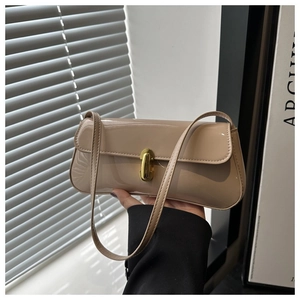 Close-up of beige patent leather bag with a vintage gold metal clasp and glossy finish
