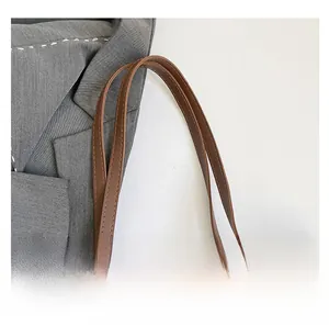 Détail des poignées de sac fourre-tout en similicuir marron avec coutures précises