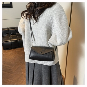 Chic black envelope square bag with magnetic closure on a stylish shoulder strap