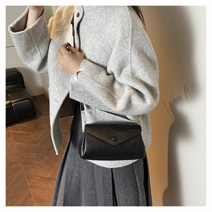 Close-up of black litchi pattern mini crossbody bag with chic envelope flap design