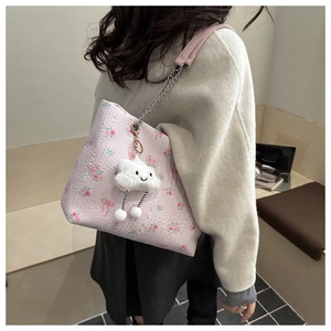 Detail of floral bucket bag with chain strap and cute cloud plush charm accessory