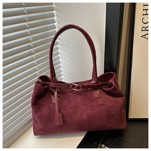 Macro detail of high-quality burgundy faux suede texture on a large capacity tote bag