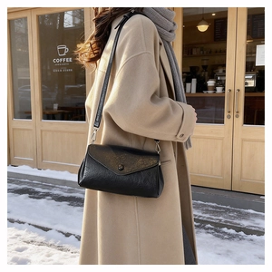 Retro black crossbody bag with vintage texture shown on a street model for style detail