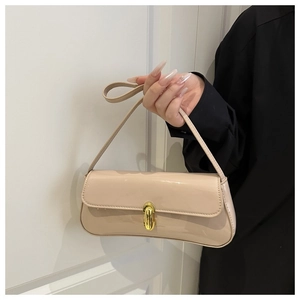 Detail of a beige patent leather baguette bag featuring a gold oval clasp and glossy finish