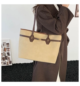 Détail du sac cabas en daim beige avec bordure en cuir marron et fermoir doré rotatif