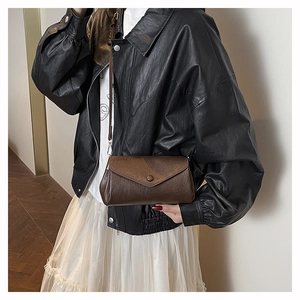 Brown faux leather crossbody envelope bag featuring button closure and slender strap
