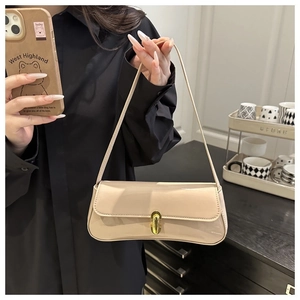 Detail of glossy beige patent leather bag with gold buckle and fine stitching