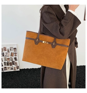 Détail du cabas en daim camel avec sangle en cuir et fermoir rotatif en métal doré