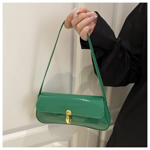 Detail of green patent leather shoulder bag with vintage gold clasp and glossy finish