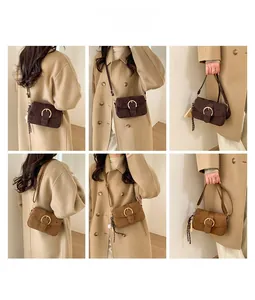 Detail of retro flap handbag featuring a gold circular buckle and adjustable leather strap