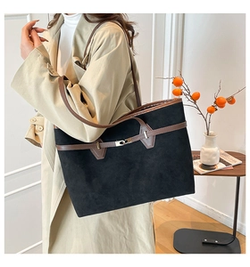 Grand sac cabas en daim noir avec bandoulières en cuir marron porté à l'épaule