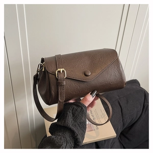 Detail of retro dark brown textured leather crossbody bag with envelope flap and buckle