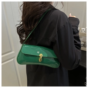 Model wearing a bright green patent leather underarm bag with vintage gold buckle detail