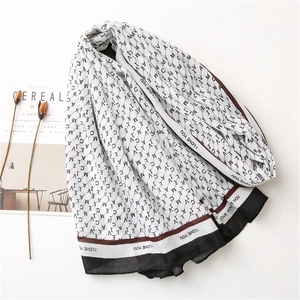 Détail d'un foulard blanc avec imprimé lettres noires et bordure de texte I LOVE YOU