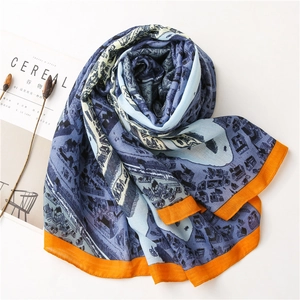 Détail d'une écharpe bleue douce avec imprimé ville et bordure cousue orange vif
