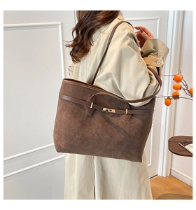 Détail du sac cabas vintage en daim marron avec fermoir pivotant et finitions en cuir