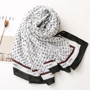 Détail d'une écharpe en coton avec imprimé lettres et texte I LOVE YOU sur le bord