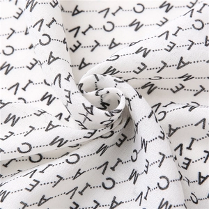 Vue macro d'un tissu blanc en coton et lin avec des motifs de lettres noires