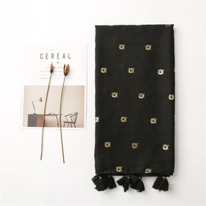 Detail of black cotton linen scarf with golden tiger embroidery and fringe tassels