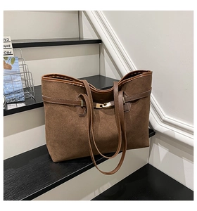 Détail du cabas vintage en daim marron avec sangle en cuir et boucle en métal doré