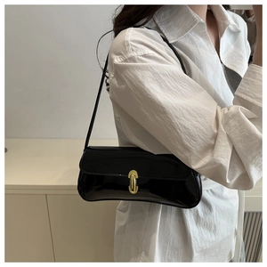 Close-up of black patent leather underarm bag with elegant gold metal buckle