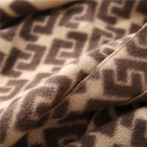 Macro detail of brown and beige jacquard scarf showing soft fiber texture and edge stitching
