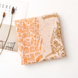 Gros plan d'une écharpe pliée élégante avec imprimé carte orange sur texture de lin