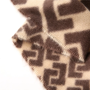Detail of double-sided cashmere-feel scarf with geometric maze pattern and fringe edges