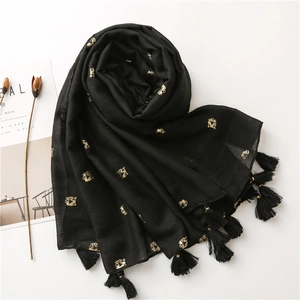 Detail of black cotton linen scarf featuring gold tiger foil print and long fringe tassels