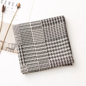 Dettaglio di sciarpa con motivo pied-de-poule e geometrico con styling minimalista