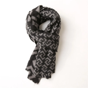 Detail of grey and black labyrinth pattern scarf with soft cashmere-like texture and tassels