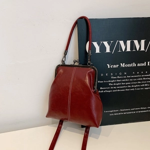 Retro red kiss-lock handbag in polished oil-wax leather with white contrast stitching