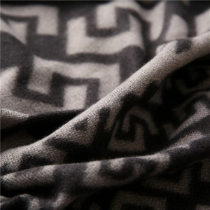 Macro shot of thick grey geometric maze pattern scarf with soft knitted texture