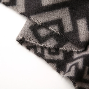 Close-up of grey and black geometric pattern cashmere scarf with soft fringed edges
